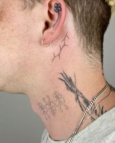 a man with tattoos on his neck and behind the ear