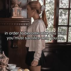 a woman standing in front of a table with food on it and an old fashioned clock behind her