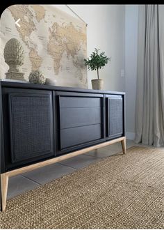 a black entertainment center in front of a window with a world map on the wall