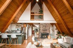 an open living room and kitchen area in a house with wood floors, vaulted ceiling