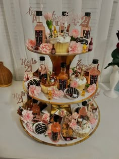 a three tiered cake with cupcakes and confections on it