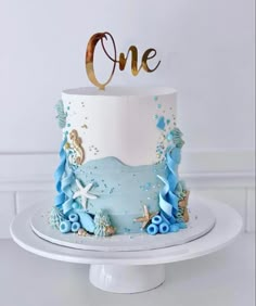 a blue and white cake with the number one on top