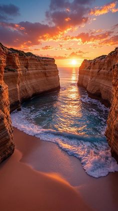 the sun is setting over the water at the ocean's edge, with cliffs in the background