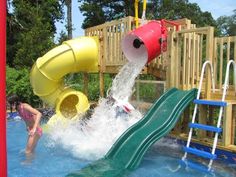 a child playing in the pool with a water slide