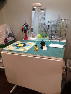 a desk with many items on it in an office area, including scissors and paper