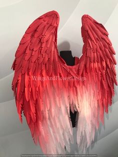 red and white angel wings hanging on a wall