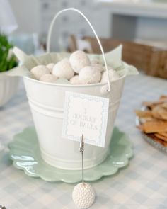 a bucket filled with white balls sitting on top of a table