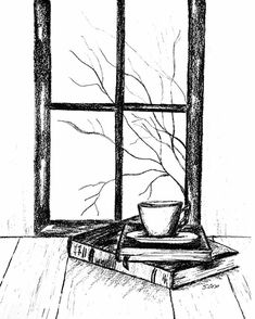 a book and cup sitting on top of a wooden table in front of a window