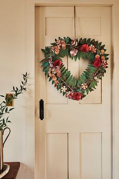 a heart shaped wreath hangs on the front door