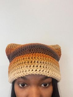 a woman wearing a crocheted hat with a cat ears on it's head