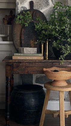 a wooden table topped with plants next to a potted plant on top of a stool