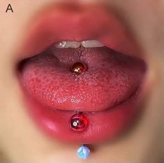 a woman's tongue with a jewel in the middle of her lip and water droplets on it