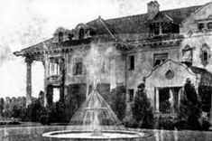 an old house with a fountain in front of it