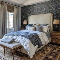 a bedroom with a large bed and blue wallpaper