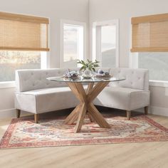 a living room scene with focus on the corner sofa and round glass top coffee table