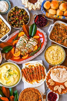 a table filled with lots of different types of food on top of plates and bowls