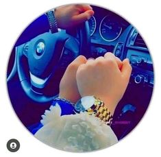 two hands on the steering wheel of a car, while another person is holding their wrist