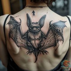 a woman with a bat tattoo on her back