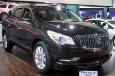 an suv is on display in a showroom with other cars and people looking at it