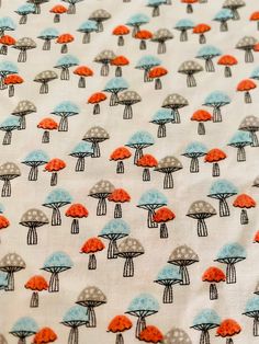 an image of mushrooms on white fabric with orange and blue dots in the middle,