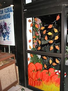 a display case filled with fake pumpkins and leaves