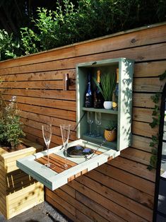 two wine glasses are sitting in an open cabinet on the side of a wooden wall