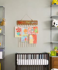 a baby's room with toys and artwork on the wall