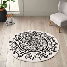 a black and white circular rug on the floor in a living room with a chair