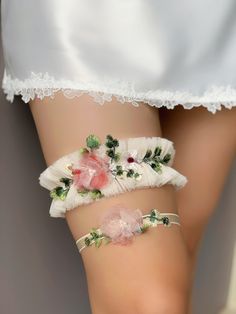 two white garters with pink flowers and green leaves on them, sitting next to each other