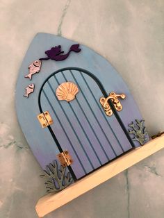 a blue and purple door with sea creatures on the front is made out of plywood