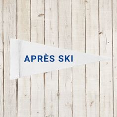 an appress ski flag hanging on the side of a wooden wall with blue writing