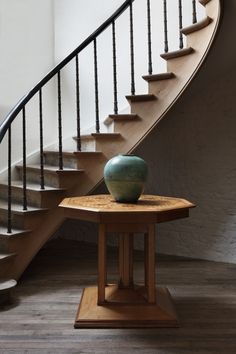 a wooden table sitting in front of a stair case