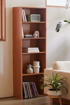 a living room with a white couch and wooden bookshelf