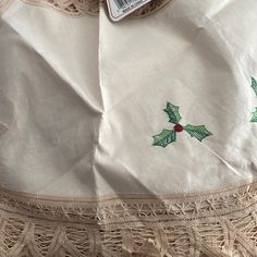 a table cloth with holly embroidered on it