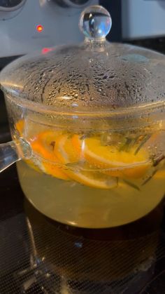 a glass pot filled with liquid and lemon slices