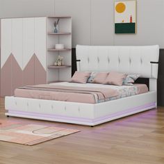 a white bed sitting on top of a hard wood floor next to a book shelf