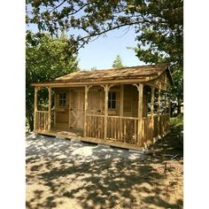 a small wooden cabin sitting in the shade