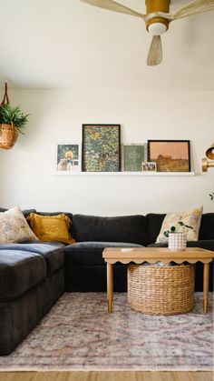 a living room with a couch, coffee table and pictures on the wall above it