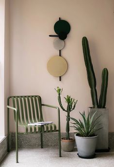 two green chairs sitting next to each other in front of a wall mounted planter