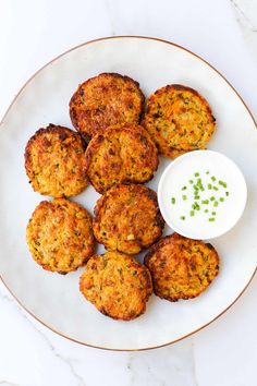 crab cakes on a plate with a small bowl of ranch dressing