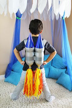 a young boy standing in front of a rocket ship