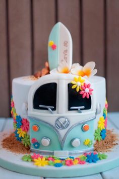 the cake is decorated with flowers and daisies on it's side, as well as an image of a vw bus