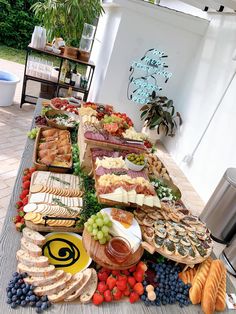 a table full of different types of cheeses and meats on display for people to eat