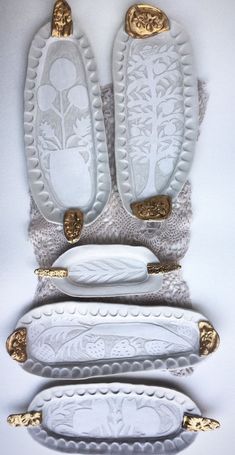 two pairs of white shoes with gold accents