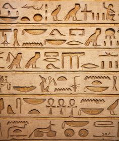 egyptian hieroglyphs on the side of a building in egypt, with an image of