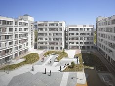 an aerial view of several buildings with people walking in the courtyard and on the ground