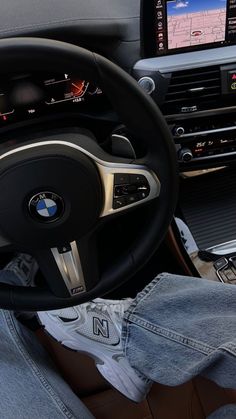 the interior of a bmw car with its steering wheel and display screen showing driving directions