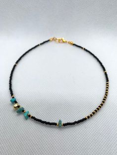 This Minimalist Heishi Seed Bead Choker in black and gold colours with blue accent will enhance you look and style, easy and comfortable to wear. Can be worn daily.  Made out of 2mm seed beads 4-6 mm turquoise beads and a gold plated hematite bead. All iteams are uniquely design and made by me.  DISPATCHING AND DELIVERY  - It would require up to three working days for items to be made and dispatched. Shipping with a Tracking Number PLEASE KEEP IN MIND, DELIVERY MIGHT TAKE LONGER THAT EXPECTED IN Black Seed Bead Necklace, Seed Bead Choker, Choker Black, Gemstone Choker, Beaded Necklace Designs, Diy Gemstone, Bead Choker, Blue Accent, Beads Bracelet Design