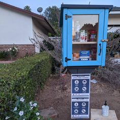 a blue and black kiosk sitting in the middle of a yard