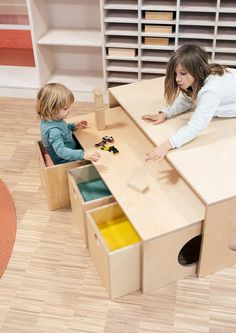 two children playing with toys in a playroom